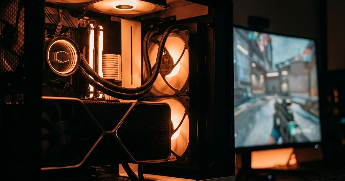 Orange-lit gaming PC interior with an FPS game on the monitor, illustrating RAM latency and performance